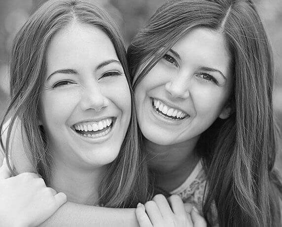 Two women with beautiful smiles after working with our dentist.